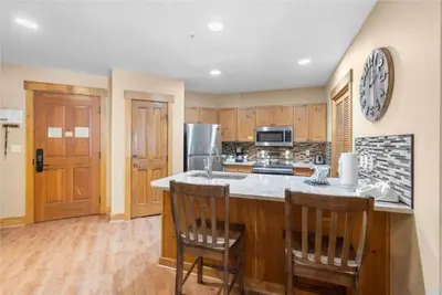 a kitchen with wooden cabinets and a counter top with two chairs at 2 Bedroom Condo At The Springs In River Run Village in Dillon