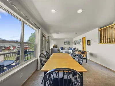 a dining room with a table and chairs and a balcony at 173 Buffalo Drive townhouse in Silverthorne