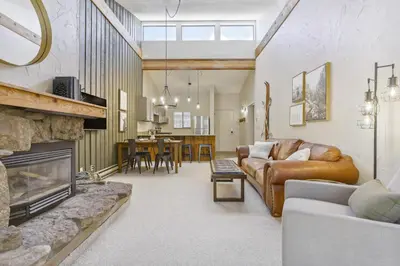 a living room with a couch and a fireplace at Cozy Winter Park Condo Bike, Ski, and Hike! in Winter Park