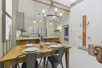 a kitchen and dining room with a wooden table and chairs at Cozy Winter Park Condo Bike, Ski, and Hike! in Winter Park
