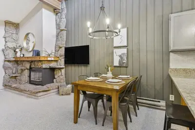 a dining room with a table and a fireplace at Cozy Winter Park Condo Bike, Ski, and Hike! in Winter Park