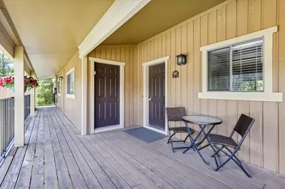a porch with two chairs and a table on a house at Cozy Winter Park Condo Bike, Ski, and Hike! in Winter Park