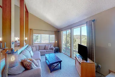 a living room with a couch and a tv at The Mountainside - Unit B47 in Granby