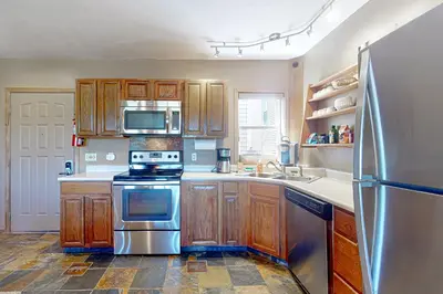 a kitchen with wooden cabinets and stainless steel appliances at The Mountainside - Unit B47 in Granby