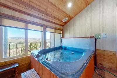 a large blue tub in a room with a window at The Mountainside - Unit B47 in Granby