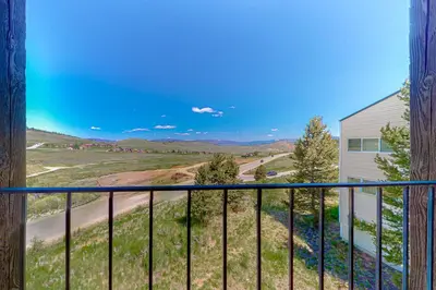 a balcony with a view of a road and mountains at The Mountainside - Unit B47 in Granby