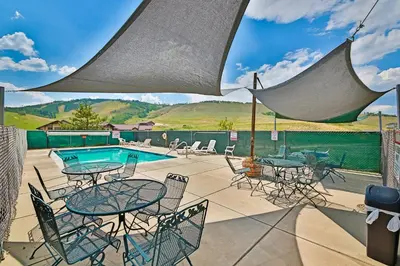 a patio with tables and chairs and a pool at The Mountainside - Unit B47 in Granby