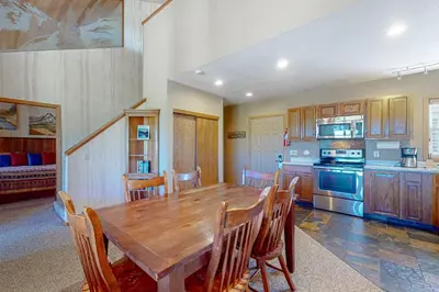 a large kitchen with a wooden table and chairs at The Mountainside - Unit B47 in Granby