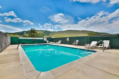 a swimming pool on a patio with chairs around it at The Mountainside - Unit B47 in Granby