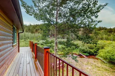 a wooden porch of a house with a tree at Deck and Mtn Views! Family A-Frame Cabin in Bailey in Highland Park