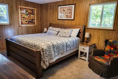 a bedroom with a bed and a chair at Deck and Mtn Views! Family A-Frame Cabin in Bailey in Highland Park