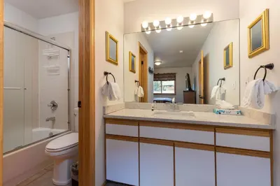a bathroom with a sink and a toilet and a mirror at 113 Cinnamon Ridge condo in Keystone