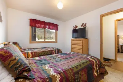 a bedroom with two beds and a flat screen tv at 113 Cinnamon Ridge condo in Keystone