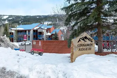 a sign in the snow in front of a lodge at 113 Cinnamon Ridge condo in Keystone