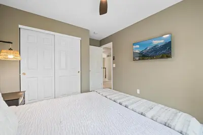 a bedroom with a white bed and a painting on the wall at Large home, Fenced in Back Yard, Cathedral Ceiling in Commerce City