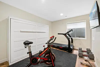 a gym with a treadmill and a bike in a room at Large home, Fenced in Back Yard, Cathedral Ceiling in Commerce City