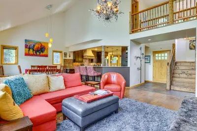 a living room with a red couch and a chair at Frisco River Gem Close to Slopes, Trails and Main St in Frisco