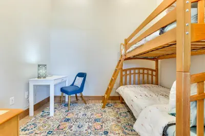 a bedroom with a bunk bed and a desk with a desk at Mountain-View Fraser Condo with Balcony and Hot Tub! in Fraser