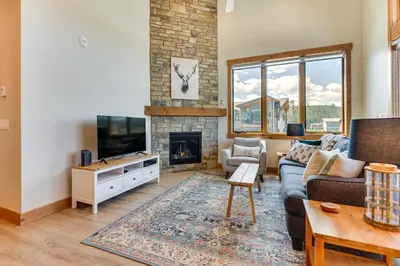 a living room with a couch and a fireplace at Mountain-View Fraser Condo with Balcony and Hot Tub! in Fraser