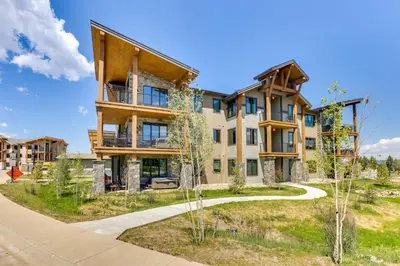 an exterior view of a large house with a driveway at Mountain-View Fraser Condo with Balcony and Hot Tub! in Fraser