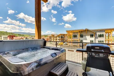 a hot tub on a balcony with a grill at Mountain-View Fraser Condo with Balcony and Hot Tub! in Fraser