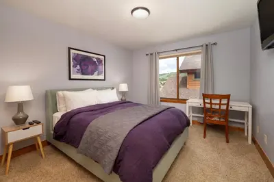 a bedroom with a bed and a desk and a window at 2002 Lupine Lane in Tabernash