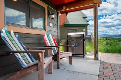a couple of chairs sitting on the side of a house with a grill at 2002 Lupine Lane in Tabernash