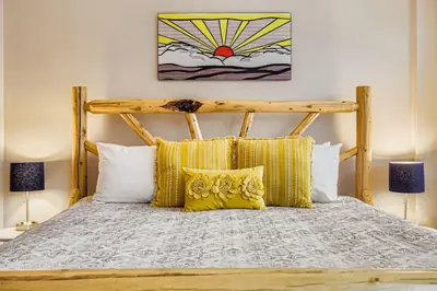 a bedroom with a wooden bed with yellow pillows at 8256 Silver Mill condo in Keystone