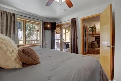 a bedroom with a large bed with a ceiling fan at 107 Woodbridge condo in Frisco