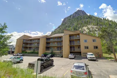 a building with cars parked in a parking lot with a mountain at 107 Woodbridge condo in Frisco