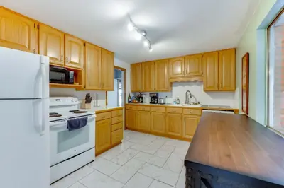 a kitchen with wooden cabinets and a white refrigerator at Pet-Friendly Gem with Private Yard in Westminster! in Westminster