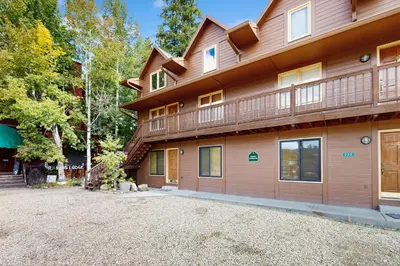 a large wooden house with a gravel driveway at On the Rapids in Grand Lake