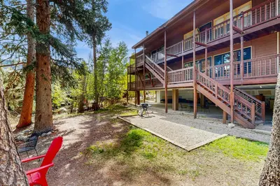 a large building with a deck and a red chair at On the Rapids in Grand Lake