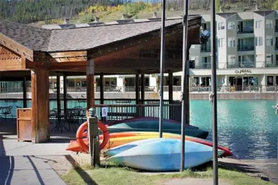 a boat sitting under a pavilion next to the water at 2 Bedroom Montezuma Condo At Lakeside Village - Shuttle To Slopes! in Keystone