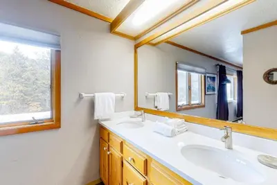 a bathroom with two sinks and a large mirror at 2 Bedroom Montezuma Condo At Lakeside Village - Shuttle To Slopes! in Keystone