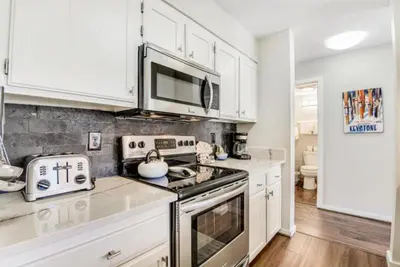 a kitchen with white cabinets and a stove top oven at Remodeled And Oversized 2-Bedroom Condo In West Keystone With Mountain Views, Pool, Hot Tub & Shuttle To Slopes! in Keystone