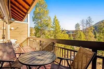 a patio with a table and chairs on a balcony at Remodeled And Oversized 2-Bedroom Condo In West Keystone With Mountain Views, Pool, Hot Tub & Shuttle To Slopes! in Keystone