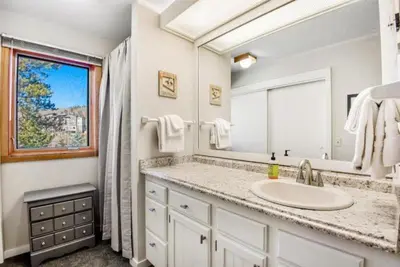 a bathroom with a sink and a mirror and a window at Remodeled And Oversized 2-Bedroom Condo In West Keystone With Mountain Views, Pool, Hot Tub & Shuttle To Slopes! in Keystone