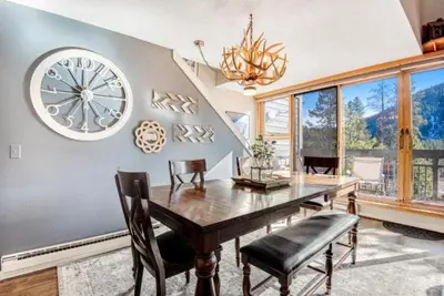 a dining room with a large clock on the wall at Remodeled And Oversized 2-Bedroom Condo In West Keystone With Mountain Views, Pool, Hot Tub & Shuttle To Slopes! in Keystone