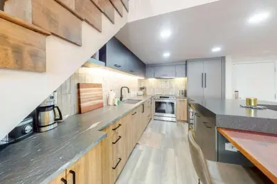 a large kitchen with wooden cabinets and stainless steel appliances at Renovated Condo In West Keystone With Balcony, Hot Tub, Pool & Free Shuttle To Slopes! in Keystone