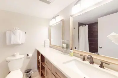 a bathroom with a sink and a toilet and a mirror at Renovated Condo In West Keystone With Balcony, Hot Tub, Pool & Free Shuttle To Slopes! in Keystone