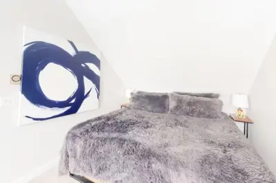 a bedroom with a bed and a painting on the wall at Renovated Condo In West Keystone With Balcony, Hot Tub, Pool & Free Shuttle To Slopes! in Keystone