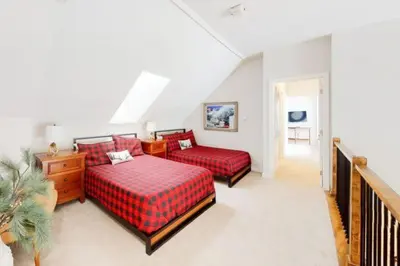 a bedroom with two beds and a staircase at Renovated Condo In West Keystone With Balcony, Hot Tub, Pool & Free Shuttle To Slopes! in Keystone