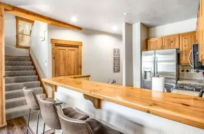 a kitchen with a wooden counter and some chairs at Lovely Townhome A Half-Mile From Keystone Gondola Wshared Hot-Tub & Excellent Views in Dillon