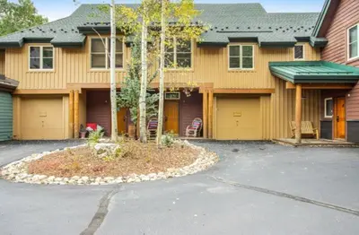 a yellow house with a driveway in front of it at Lovely Townhome A Half-Mile From Keystone Gondola Wshared Hot-Tub & Excellent Views in Dillon
