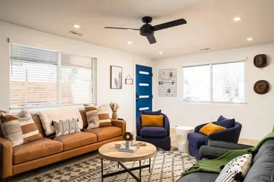 a living room with two couches and a table at Wild West Disco Haus 2! New Hot Tub, Patio + Gym in Denver