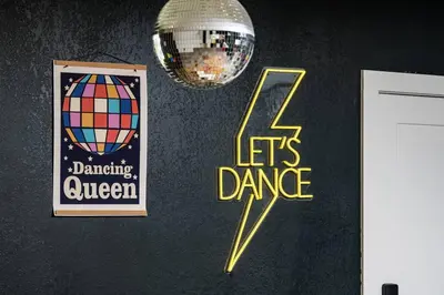 a wall with two posters and a disco ball at Wild West Disco Haus! New Hot Tub, Patio + Gym in Denver