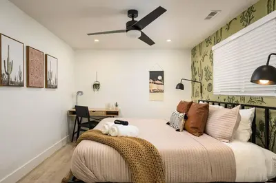 a bedroom with a bed with a ceiling fan at Wild West Disco Haus! Sleeps 12, Hot Tub + Gym! in Denver