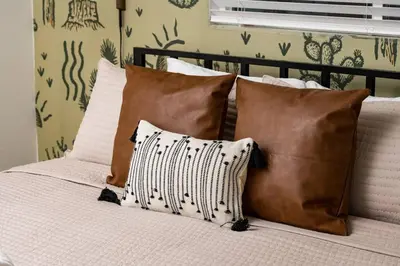 a bed with brown and white pillows on it at Wild West Disco Haus! Sleeps 12, Hot Tub + Gym! in Denver