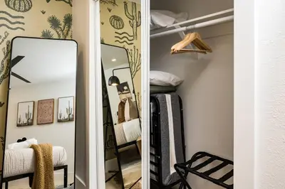 a dressing room with a mirror and a bed at Wild West Disco Haus! Sleeps 12, Hot Tub + Gym! in Denver